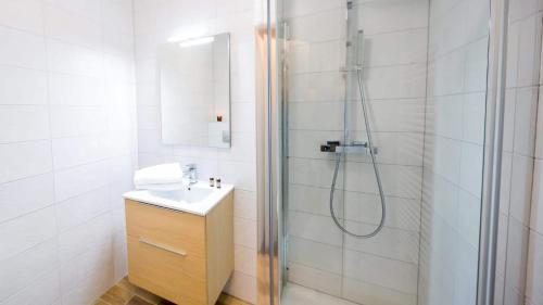une salle de bain blanche avec une douche et un lavabo dans l'établissement Les 4 Elements - Apt C102 - BO Immobilier - Châtel, à Châtel