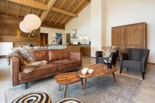 un salon avec un canapé marron et une table dans l'établissement Le Mont Royal - Apt A301 - BO Immobilier, à Châtel