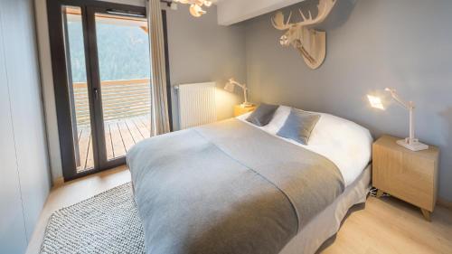 1 dormitorio con cama y ventana grande en Les 360 - Apt 2 - BO Immobilier, en Châtel