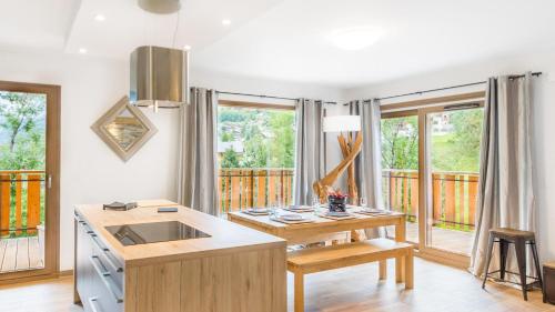 - une cuisine avec un évier et une table ainsi que quelques fenêtres dans l'établissement Les 4 Elements - Apt C102 - BO Immobilier - Châtel, à Châtel