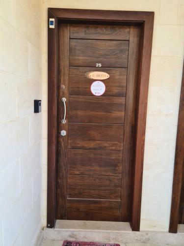 a wooden door in a building with a sign on it at Il Bejta penthouse in Qala
