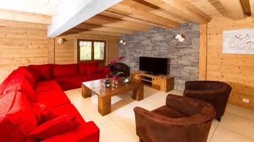 - un salon avec un canapé rouge et une cheminée dans l'établissement Chante Bise - Chalet - BO Immobilier, à Châtel