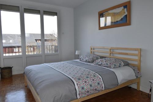 een slaapkamer met een bed met 2 kussens erop bij chanteraine 2 in Reims
