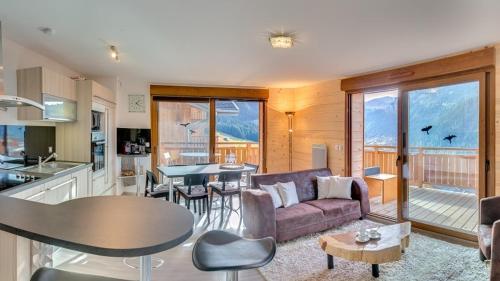 un salon avec un canapé et une table dans l'établissement Le Bellevue - Apt - BO Immobilier - Châtel, à Châtel