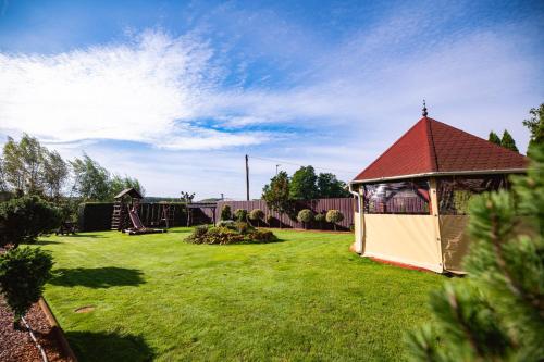 a yard with a gazebo in the grass at Fenyves Csárda Vendégház in Nyíradony