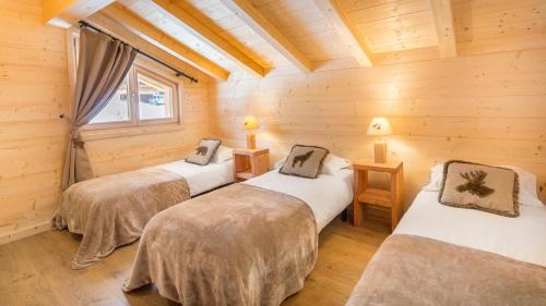 a room with two beds in a log cabin at Le Ciste - Chalet - BO Immobilier in La Chapelle-dʼAbondance