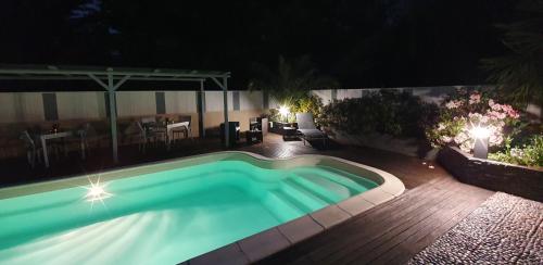 a swimming pool in a yard at night at Les Centauris in Pléguien
