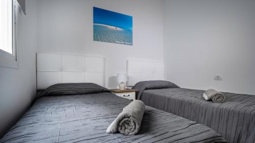 a bedroom with two beds and a picture on the wall at Cotillo Sea 2 in Cotillo