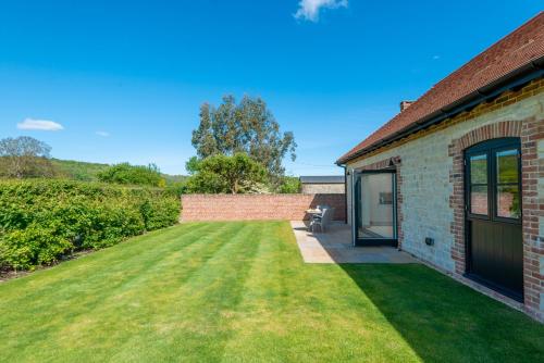 a brick house with a lawn in front of it at Barrow Hill Barns in Petersfield