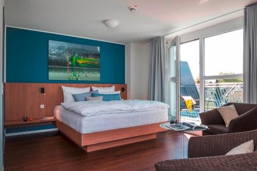 een slaapkamer met een groot bed met een blauwe muur bij Mintrops Concierge Hotel in Essen
