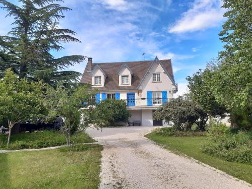 une maison avec un chemin de terre devant elle dans l'établissement La maison bleue, à Corpeau