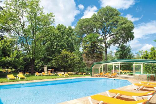 a swimming pool with lounge chairs and a house at Logis Hôtel Restaurant Les Cèdres in Joyeuse