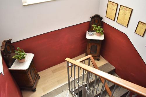 a stairway with a red and white wall with two plants at Villa Scalabrini in Como