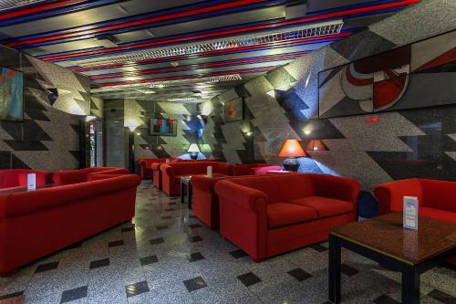 a waiting room with red chairs and a wall with a mural at Hotel Nacional in Lisbon