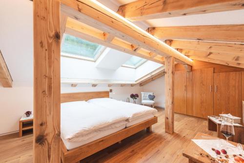 a bed in a room with wooden walls and ceilings at Jolimont Apartments in Zermatt