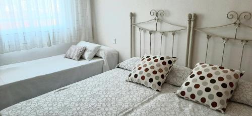2 camas con almohadas de lunares en un dormitorio en Apartamento Realengo Sevilla, en Sevilla