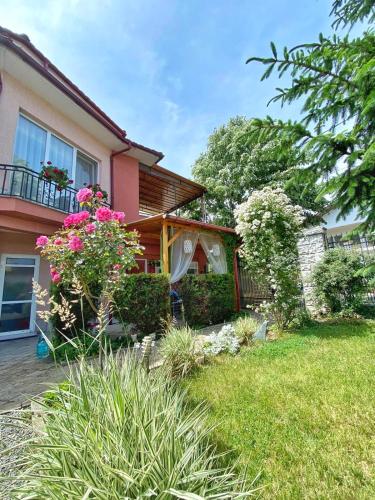 a house with a yard with flowers in front of it at Casa Constantin si Elena ( Adults only ) in Eforie Nord