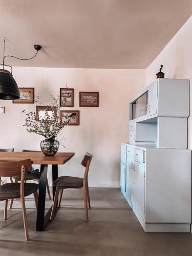 a kitchen with a table and a white refrigerator at Pr' Kramarju - House in the heart of Kobarid in Kobarid