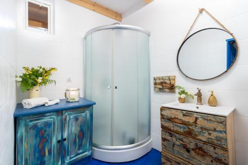 a bathroom with a glass shower and a blue wooden cabinet at Domek Na Polanie in Budzów