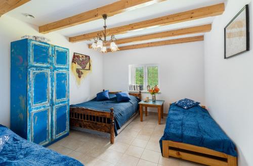 a bedroom with two beds and a blue door at Domek Na Polanie in Budzów