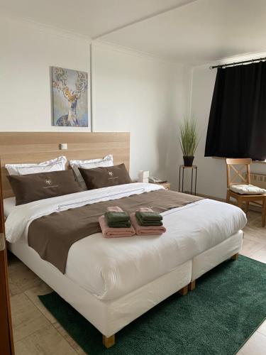 een slaapkamer met een groot bed en 2 handdoeken bij Hotel The New Fox in Affligem