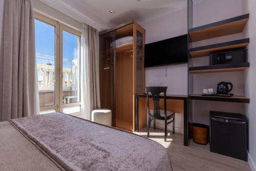 a hotel room with a bed and a desk and a window at Hotel Europa in Madrid