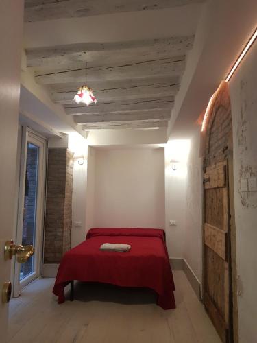um quarto com uma cama com um cobertor vermelho em golden place em Veneza