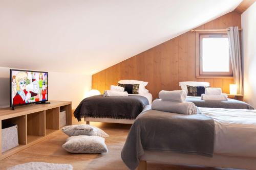 - une chambre avec 2 lits et une télévision dans l'établissement Appartement Le Mazot Vue Mont Blanc, à Chamonix-Mont-Blanc