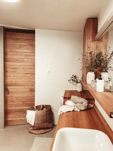 a bathroom with a white tub and a wooden door at Pr' Kramarju - House in the heart of Kobarid in Kobarid