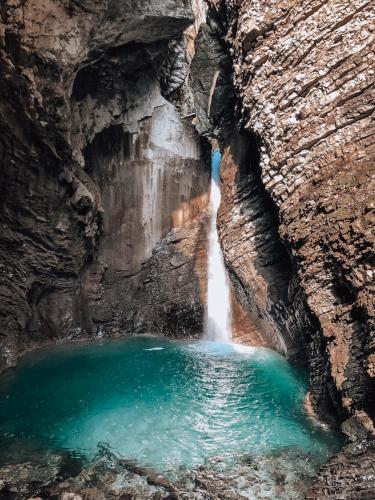 a pool of water in a cave with a waterfall at Pr' Kramarju - House in the heart of Kobarid in Kobarid