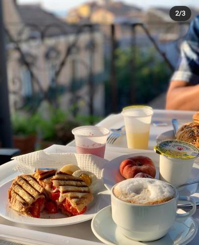 a table with a plate of food and a cup of coffee at Hotel Biscari in Catania