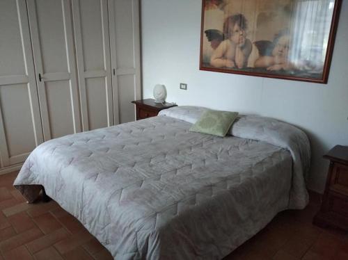 a bed in a bedroom with a picture on the wall at Agriturismo Il Selvello in Montemassi