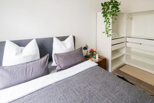 1 dormitorio con 1 cama con almohadas moradas y blancas en theleaf - design apartment & café, en Leipzig