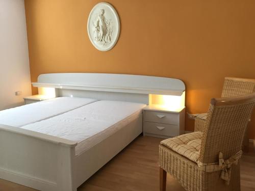- une chambre avec un lit blanc et une chaise dans l'établissement Ferienhaus Zerrer, à Zarrendorf