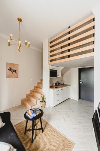 a living room with a staircase and a table at BOHO HOUSE in Ustrzyki Dolne