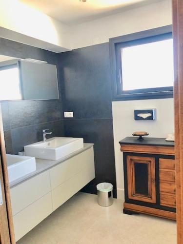 une salle de bain avec un lavabo blanc et une fenêtre dans l'établissement VILLA PADI La Cadière d'Azur, à Laouque
