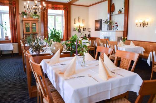 a dining room with tables with white tablecloths at Hotel Fortuna in Stockach