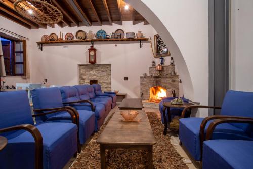 a living room with blue couches and a fireplace at Lazaros Stonehouse in Pano Lefkara