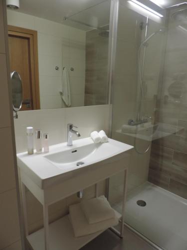 ein Bad mit einem Waschbecken und einer Dusche in der Unterkunft Apartament 514 Seaside z widokiem na morze in Kołobrzeg