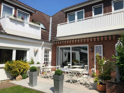 a house with a patio with a table and chairs at Pension Maren in Büsum