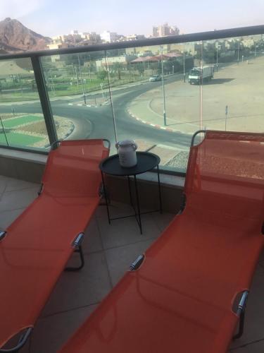a room with red seats and a table and a view of a race track at CHAMBRES D’HÔTES EILAT in Eilat