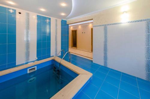 a blue bathroom with a tub and a shower at Шале "Ведмежий Двір" in Palyanytsya