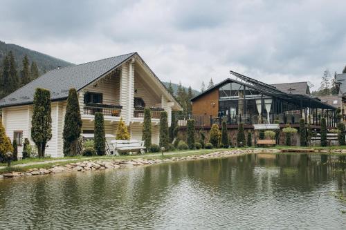 a house with a lake in front of it at Шале "Ведмежий Двір" in Palyanytsya