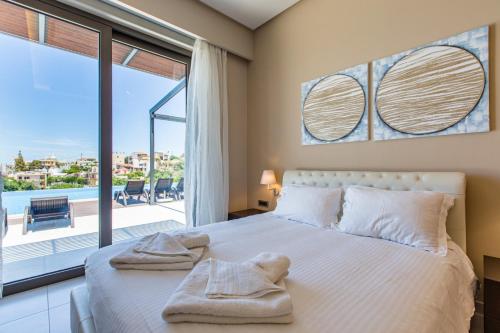 a bedroom with a bed and a large window at Winehill Villa in Platanias