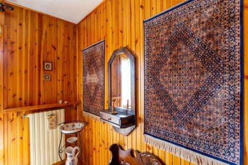 ein Badezimmer mit Holzwänden, einem Waschbecken und einem Spiegel in der Unterkunft Casa Dello Sciatore in Roccaraso