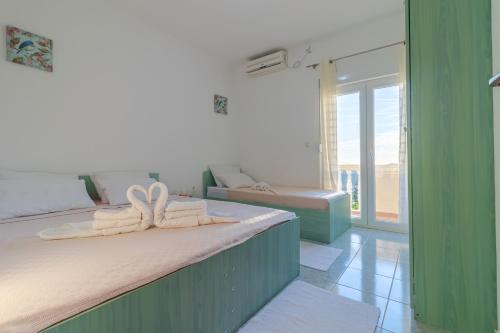 a bedroom with two beds with towels on them at Room Dragičević with Garage in Budva