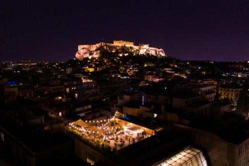 - une vue sur une ville la nuit avec un château dans l'établissement Ergon House Athens, à Athènes