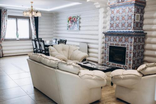 a living room with two couches and a fireplace at Шале "Ведмежий Двір" in Palyanytsya