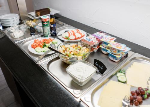a buffet with food on a table with food at Hanse Hotel Buxtehude in Buxtehude