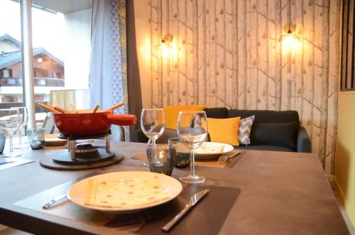 une table avec des assiettes et des verres à vin dessus dans l'établissement Elégant et moderne, au pied du Mont-Blanc, à Saint-Gervais-les-Bains